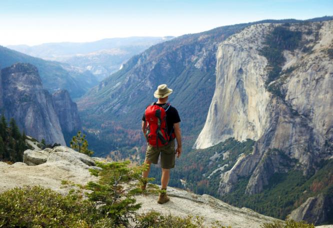Reise in Vereinigte Staaten von Amerika, Wanderer blickt vom North Dome ins Yosemite Valley, Yosemite-Nationalpark, Kalifornien
